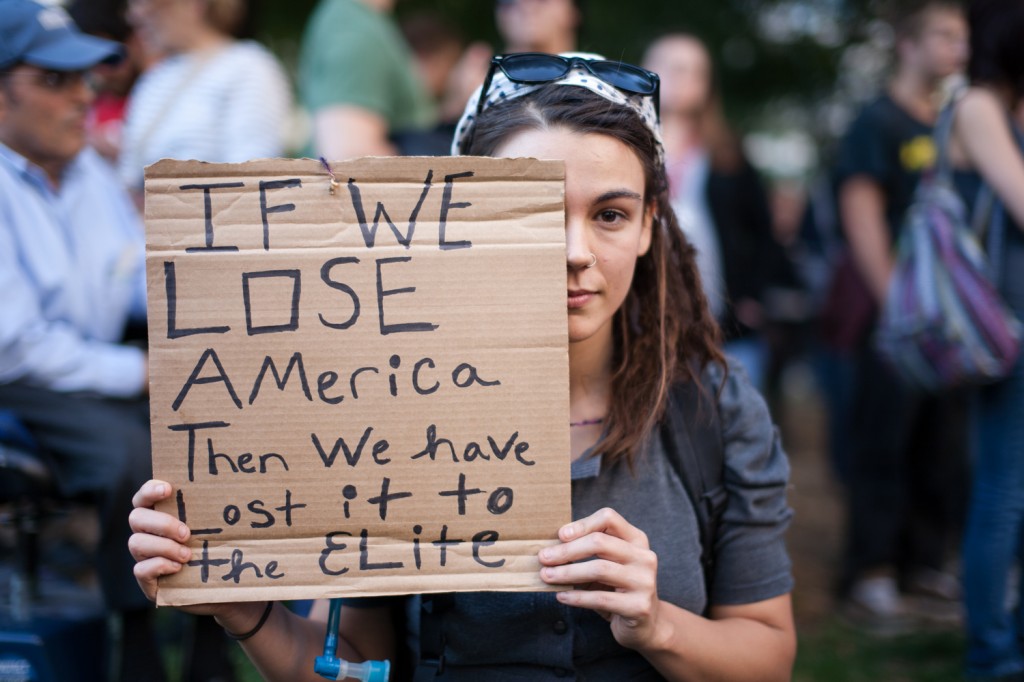 Girl holding up sign: If we lose America, then we have lost it to the elite.